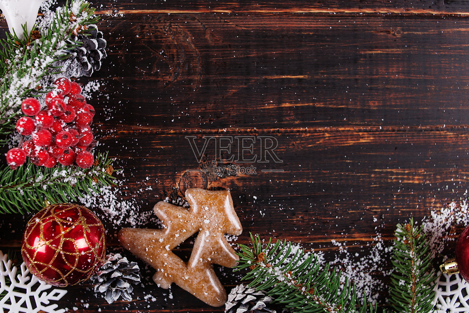 圣诞背景，冷杉树，手工装饰和姜饼饼干放在木桌上，被白雪压碎，拷贝空间，俯视图。照片摄影图片