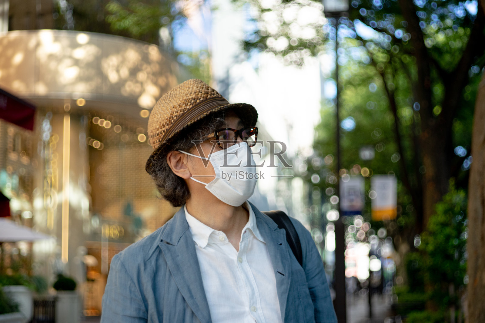 戴着口罩走在东京街头的男人照片摄影图片