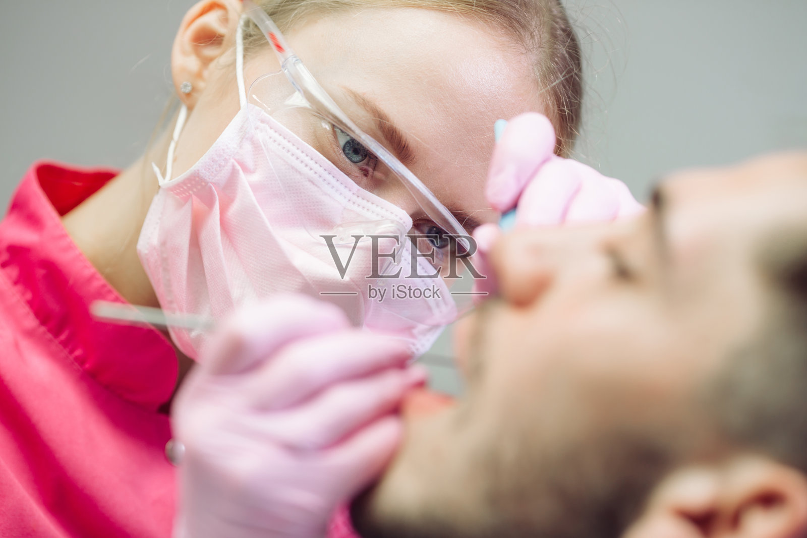 专业牙齿清洁。牙医为男病人清洁牙齿。照片摄影图片