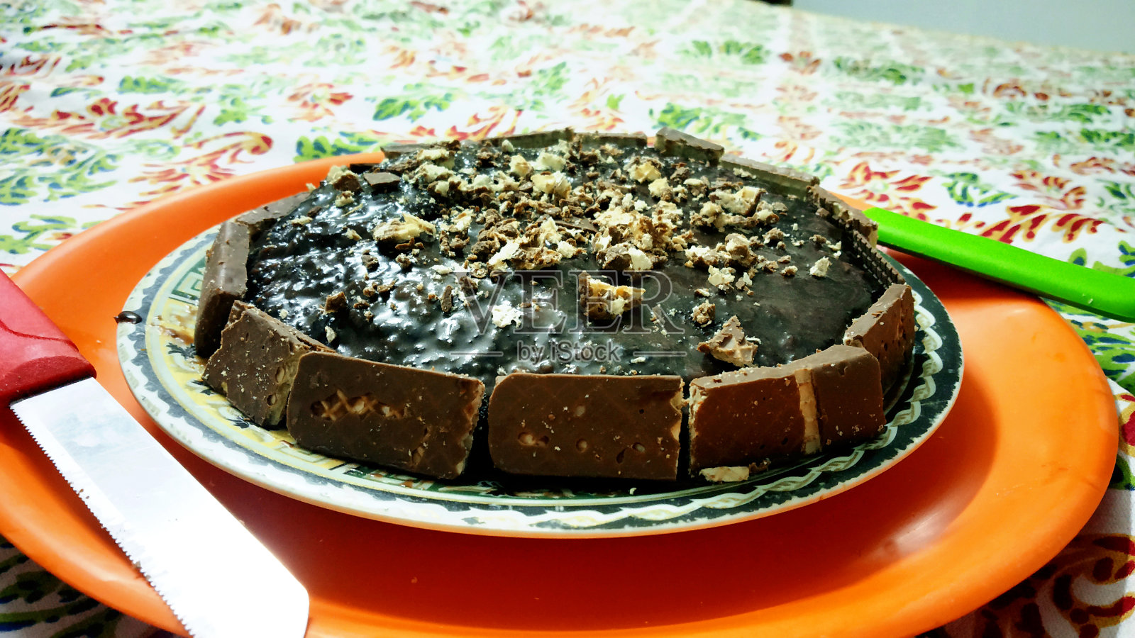 一个俯视图的黑巧克力蛋糕全，放在彩色盘子与两把刀照片摄影图片