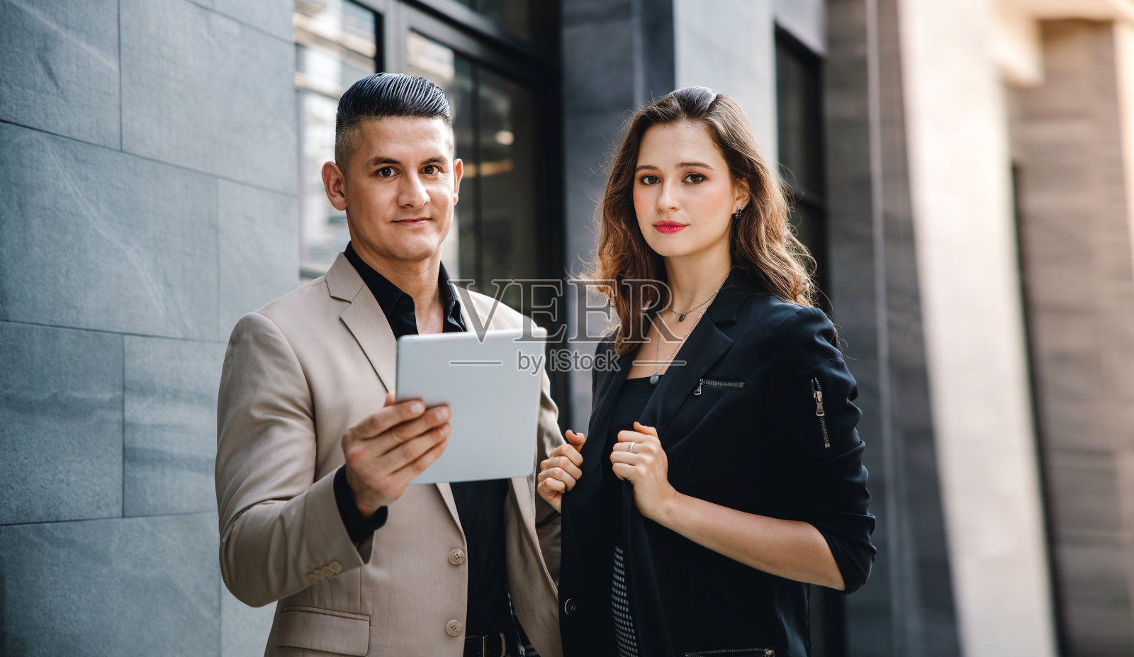 团队合作或一起工作的概念。商人和商业女性在办公室外使用平板电脑的肖像照片摄影图片