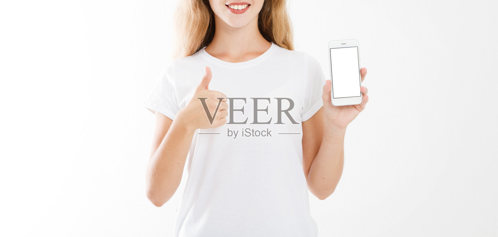 年轻的白人妇女，女孩在t恤拿着空白屏幕手机显示一个或像计数孤立在白色的背景。本空间照片摄影图片