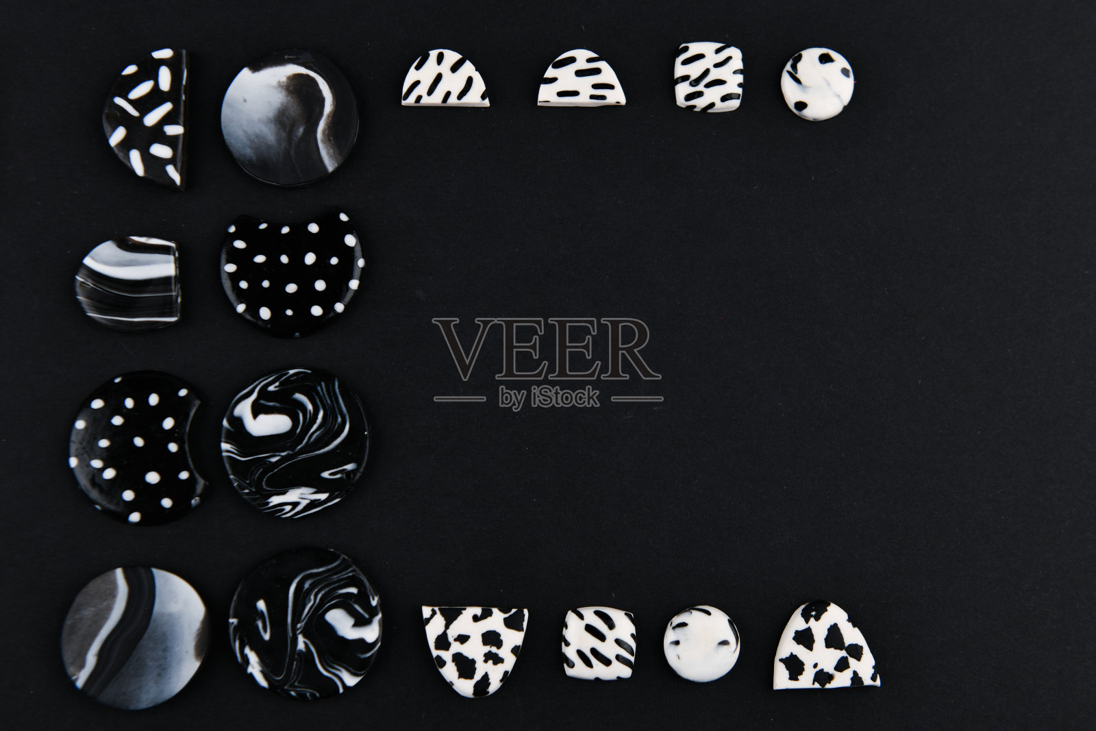 软陶一种由软陶制成的产品黑色和白色的软陶。手工雕刻，产品耳环上的黑色背景。从以上观点。黑色和白色的珠宝耳环。手工软陶首饰照片摄影图片