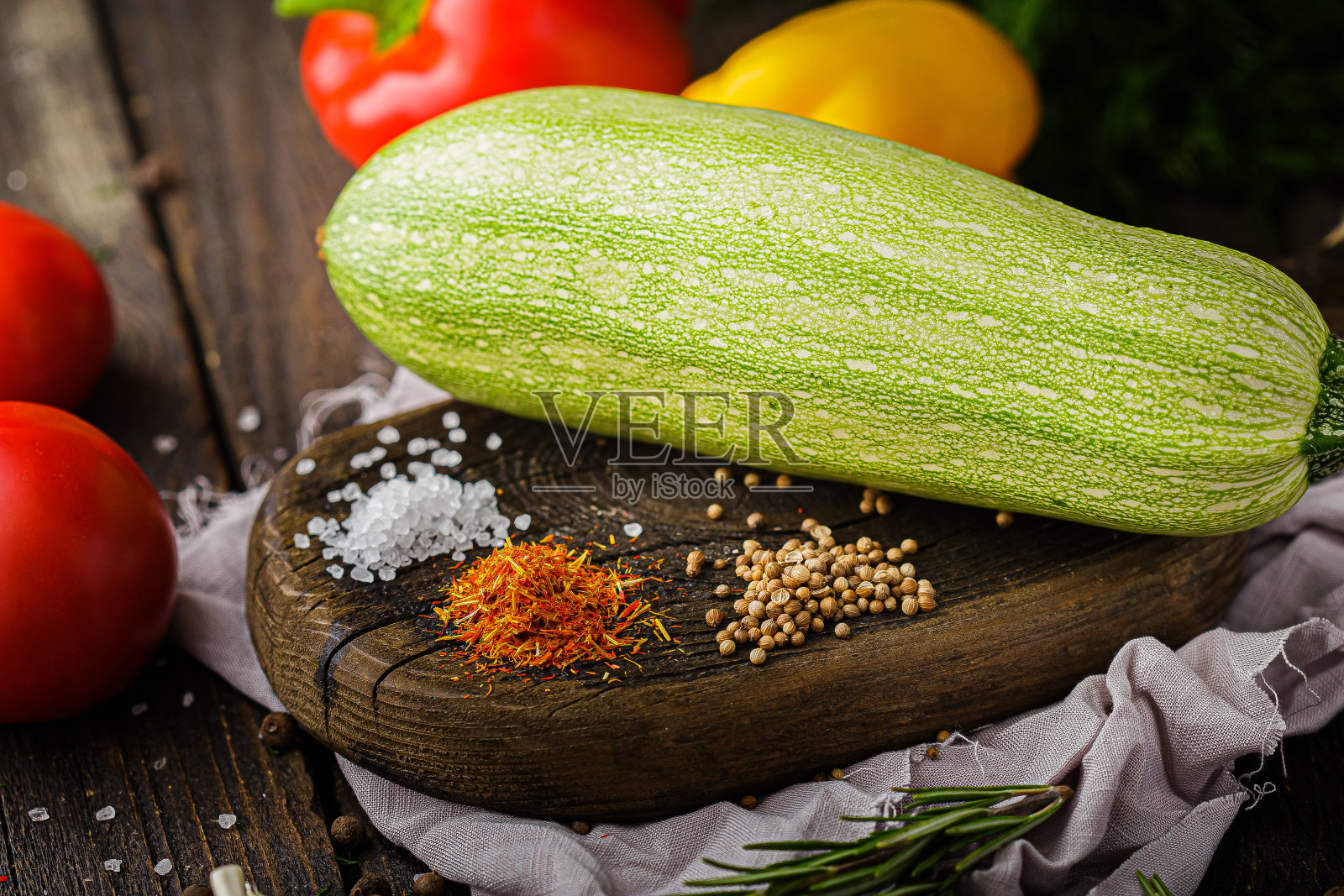 整个西葫芦，香料和粗盐，乡村风格，樱桃番茄枝，在黑色的背景照片摄影图片