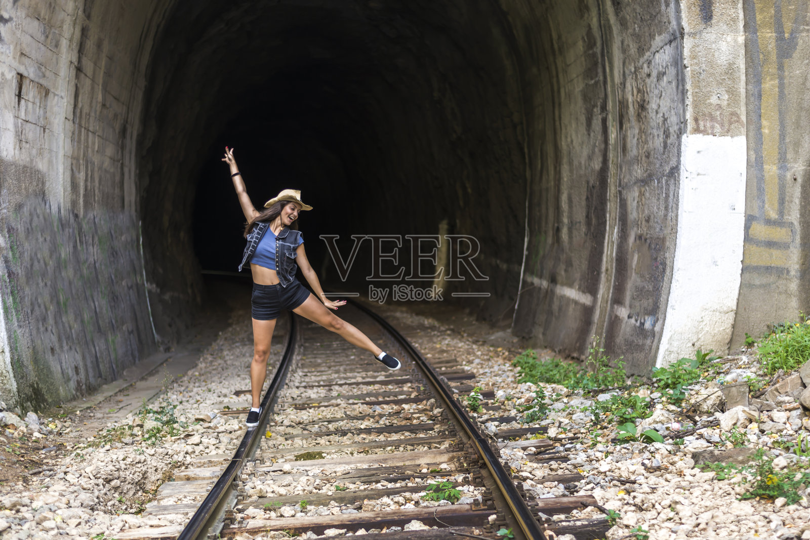 一个漂亮的年轻女子在铁轨上玩得很开心。照片摄影图片
