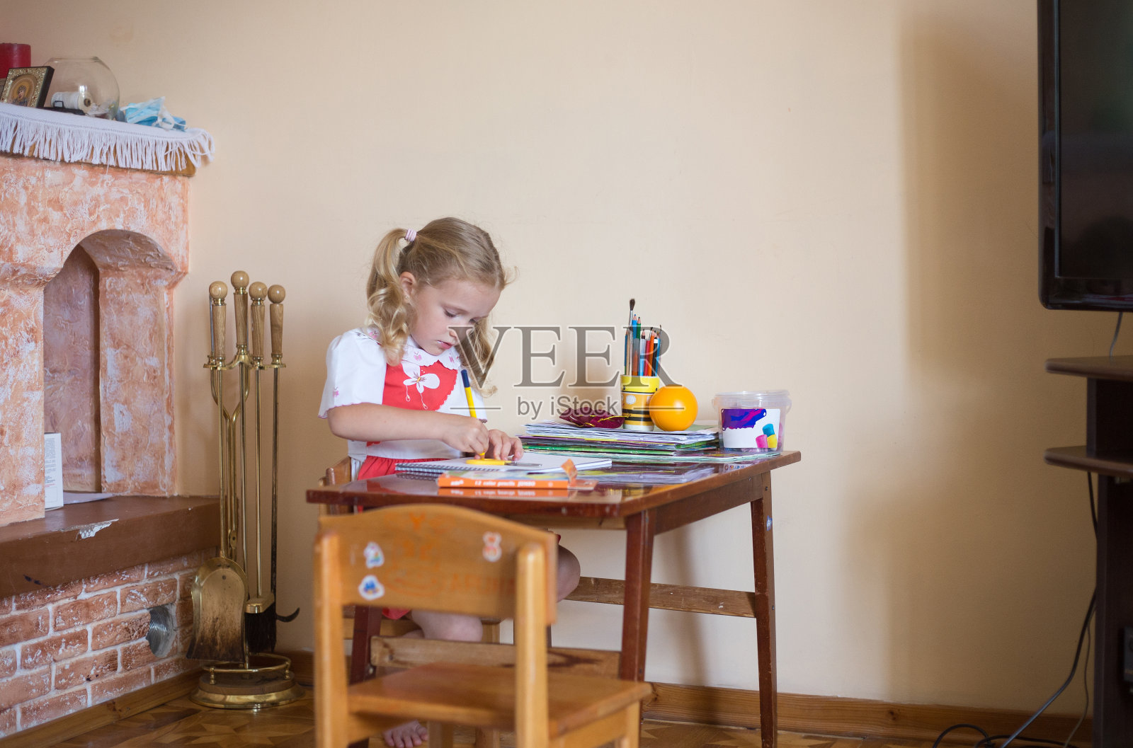 小女孩在素描本上用铅笔画画照片摄影图片