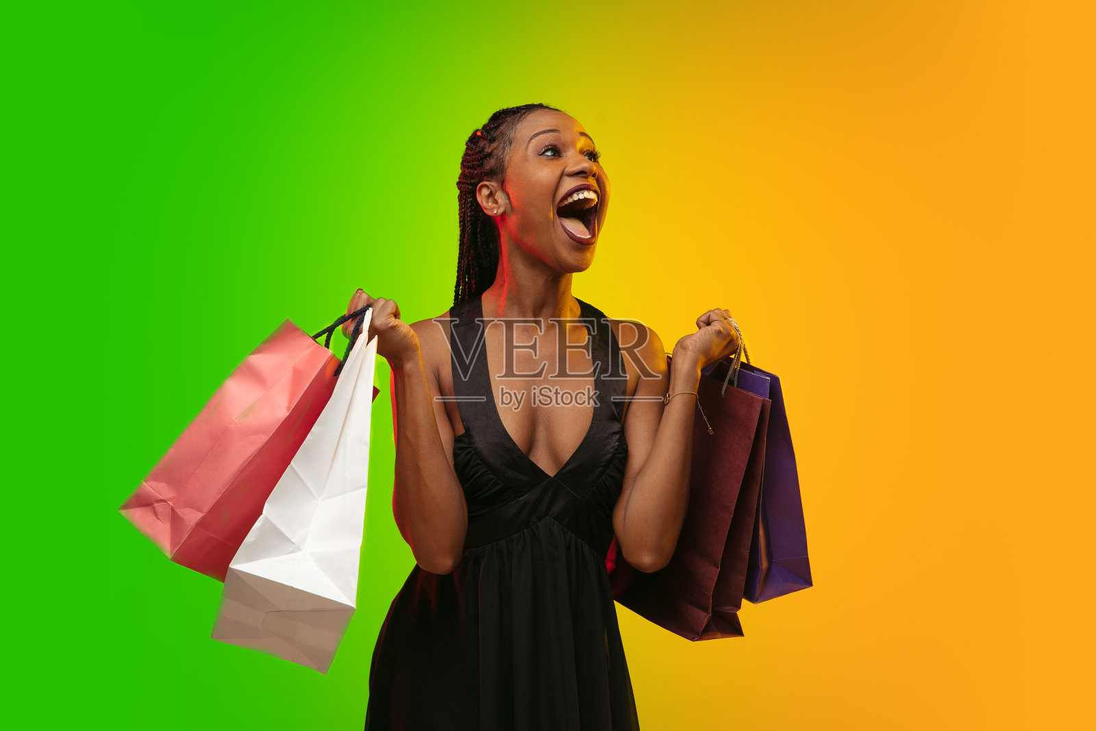 年轻女子的肖像在霓虹灯梯度背景。人类情感，黑色星期五，网络星期一，购买，销售，财务概念。照片摄影图片