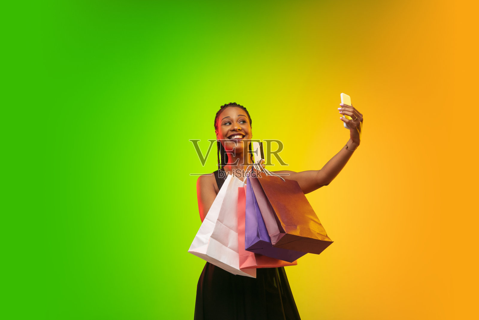 年轻女子的肖像在霓虹灯梯度背景。人类情感，黑色星期五，网络星期一，购买，销售，财务概念。照片摄影图片