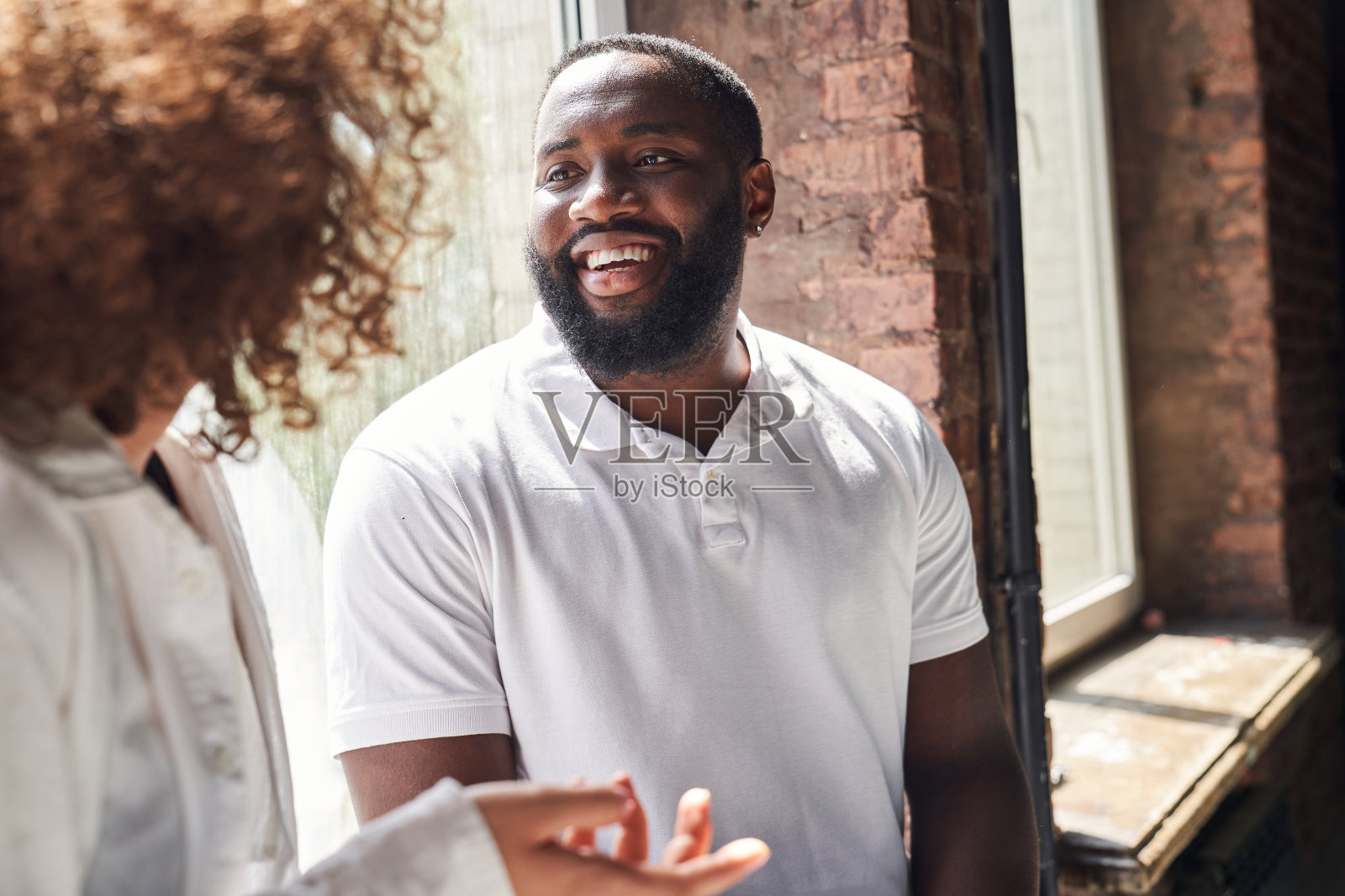 快活的非洲裔美国人在和一个女人说话照片摄影图片