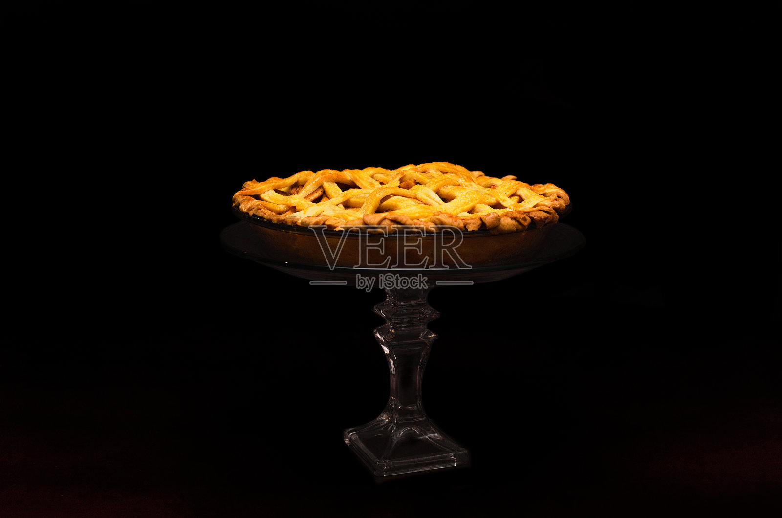 玻璃底座上的苹果派。照片摄影图片