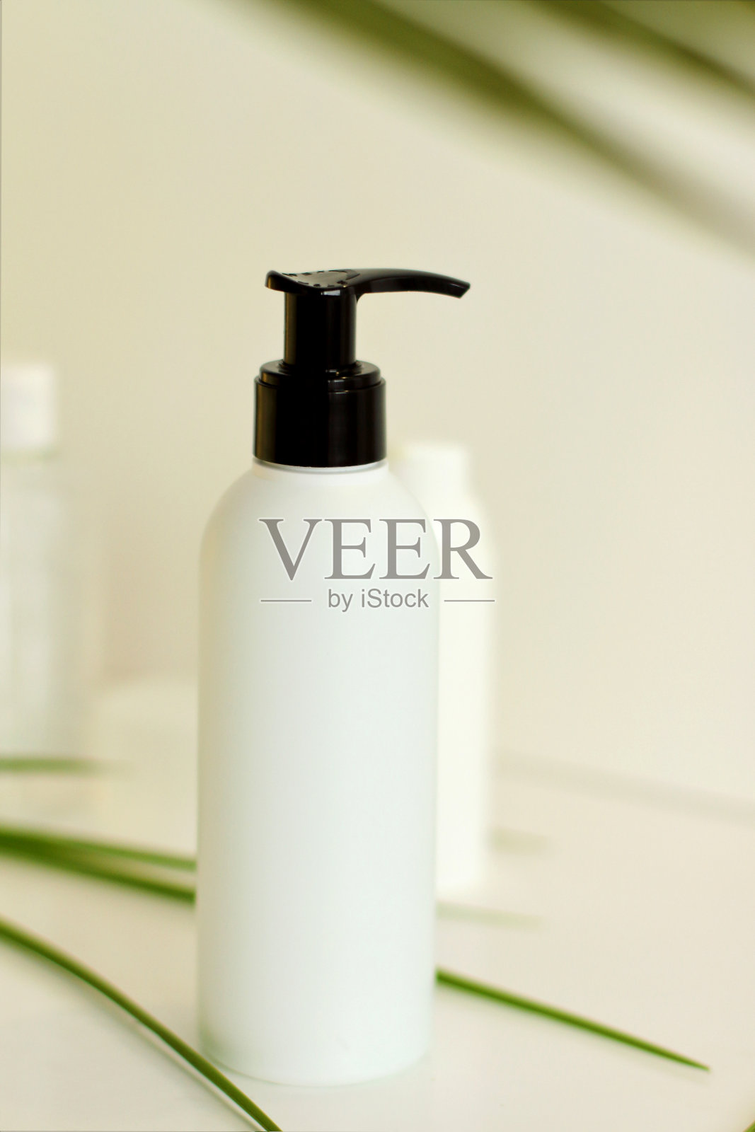 白色塑料罐与绿色的叶子背景照片摄影图片