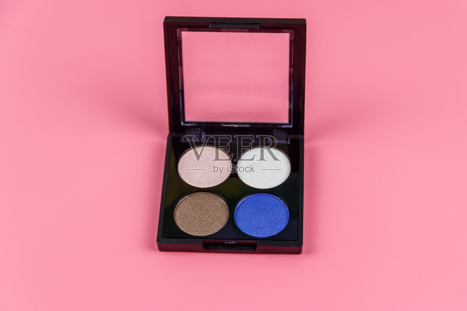 一套四个圆形的眼影在一个塑料黑色的盒子，在一个柔和的粉红色背景。平躺照片摄影图片
