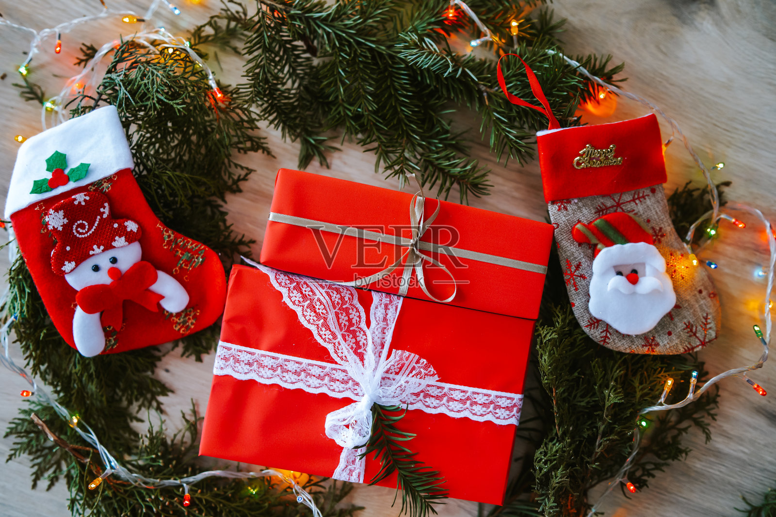 女人的手和圣诞礼物盒的桌子上有装饰照片摄影图片