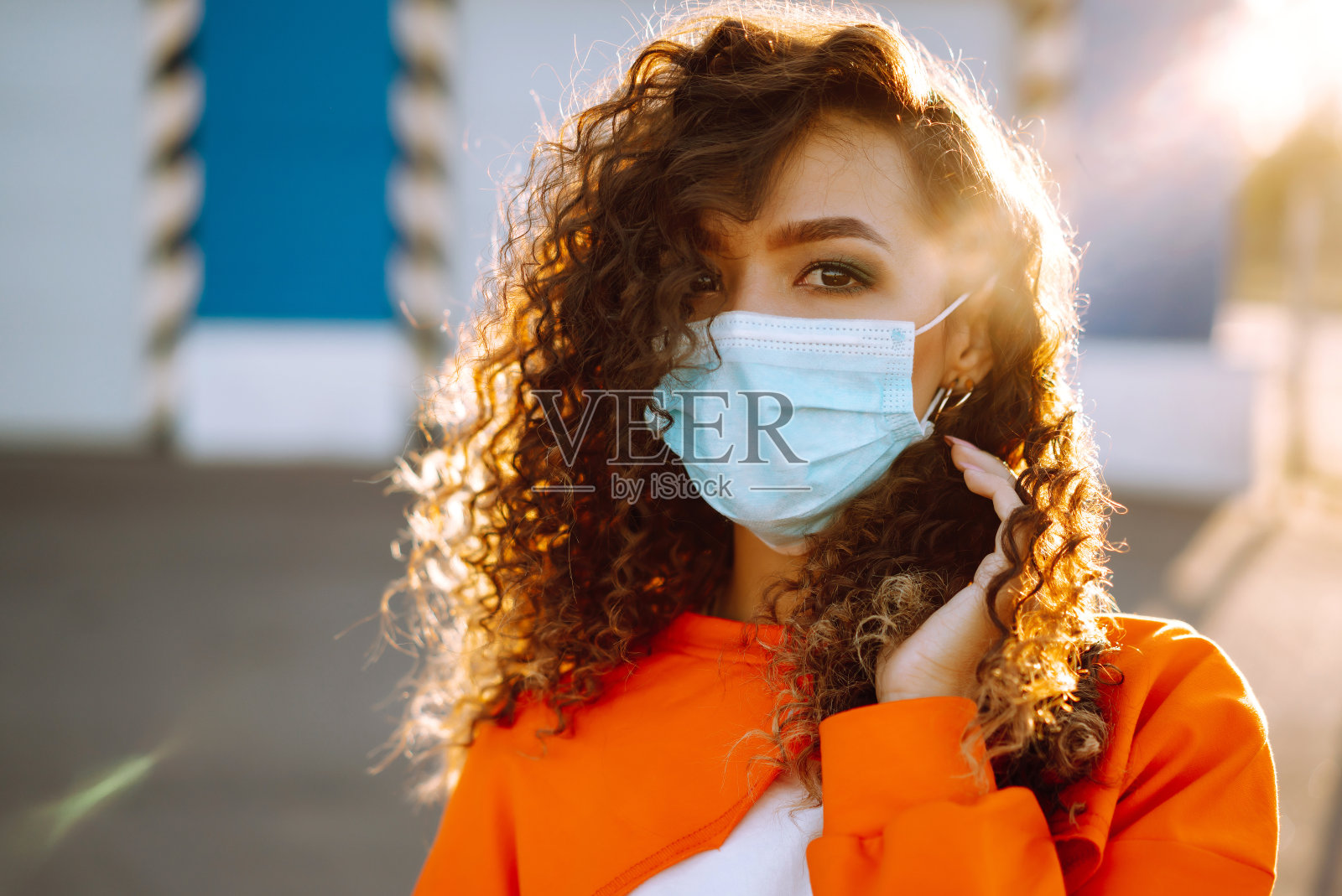 戴口罩的年轻女子在日落时分照片摄影图片