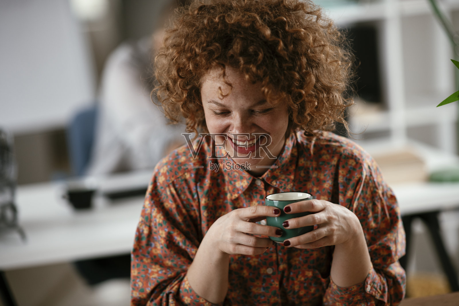 年轻的女商人在办公室喝咖啡。照片摄影图片