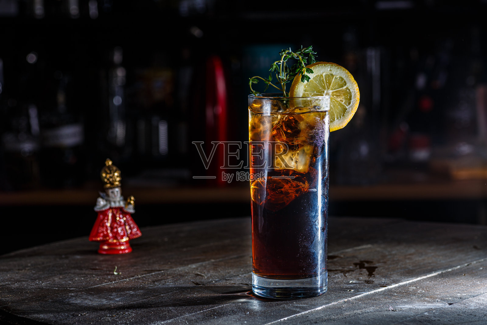 深色吧台的柜台上放着一杯棕色鸡尾酒或柠檬水和可乐。照片摄影图片