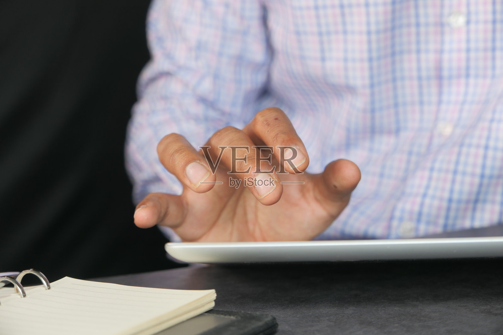 一名男子的手在办公桌旁摆弄着平板电脑，照片摄影图片