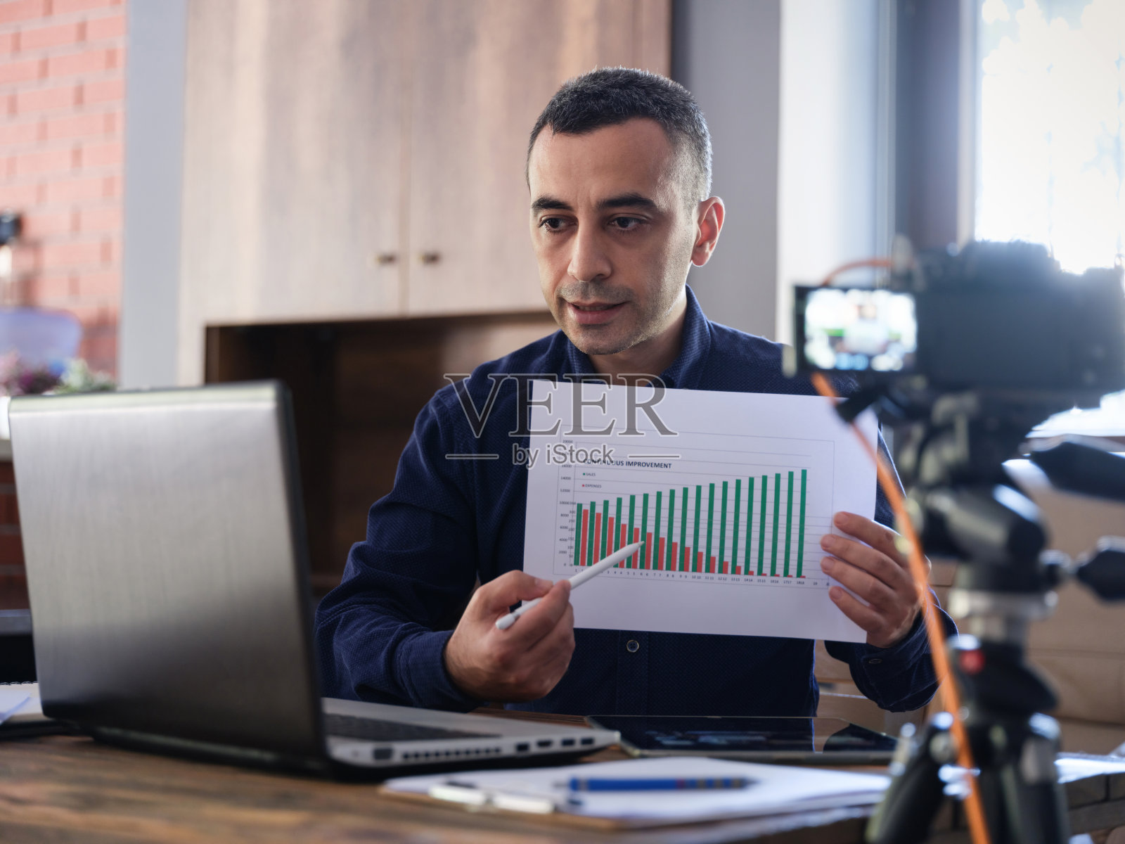 一个人正在用笔记本电脑在家办公，并在网络研讨会上做演讲照片摄影图片