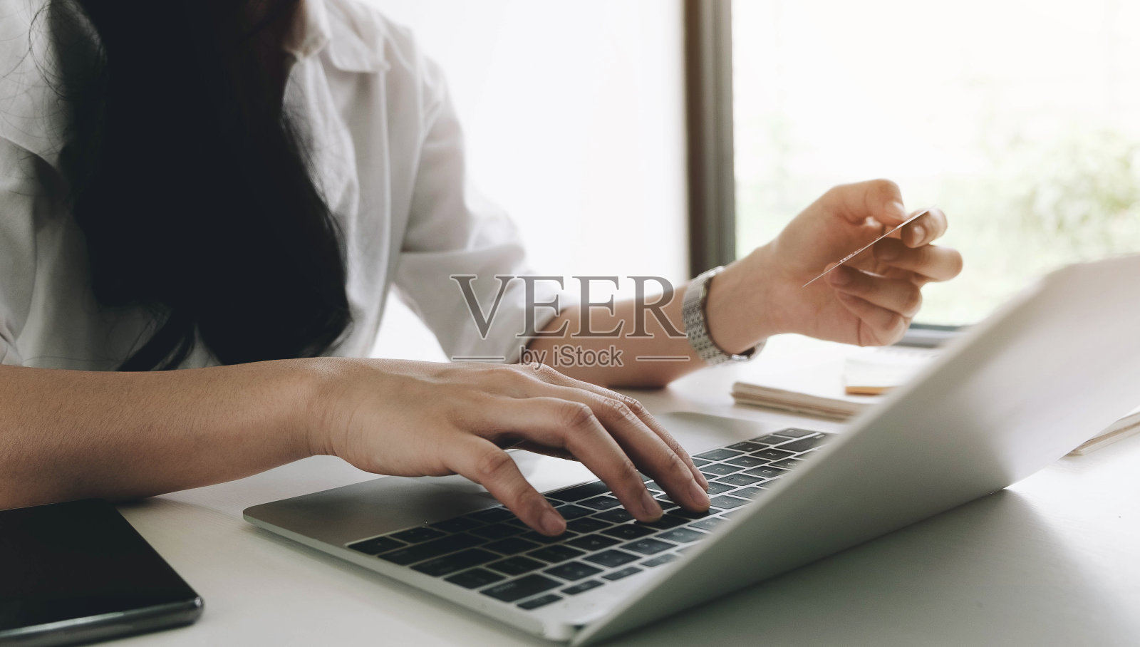 在线支付：女子使用智能手机信用卡进行网购照片摄影图片