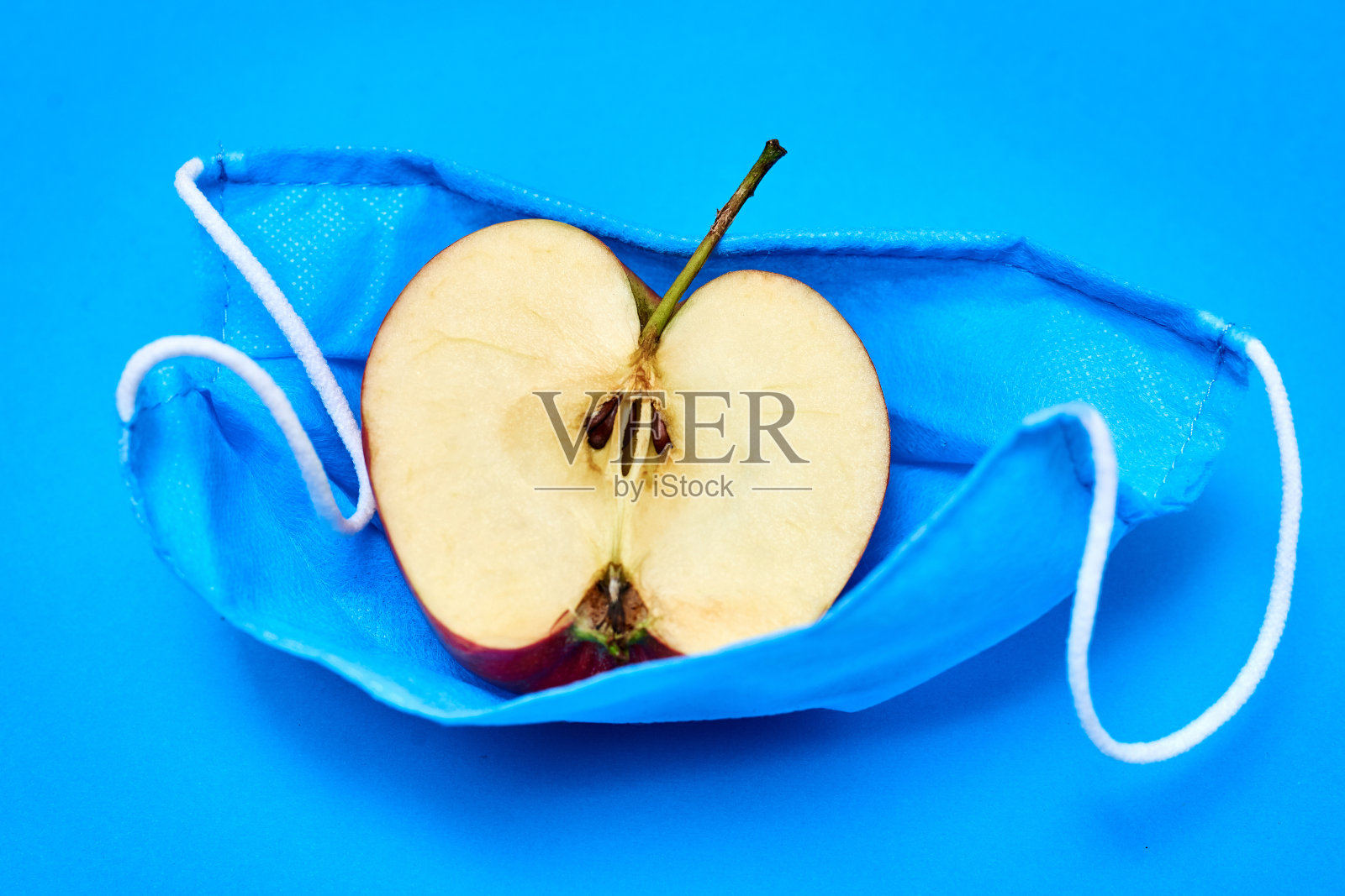 清新、健康的呼吸理念。戴着医用口罩的苹果照片摄影图片