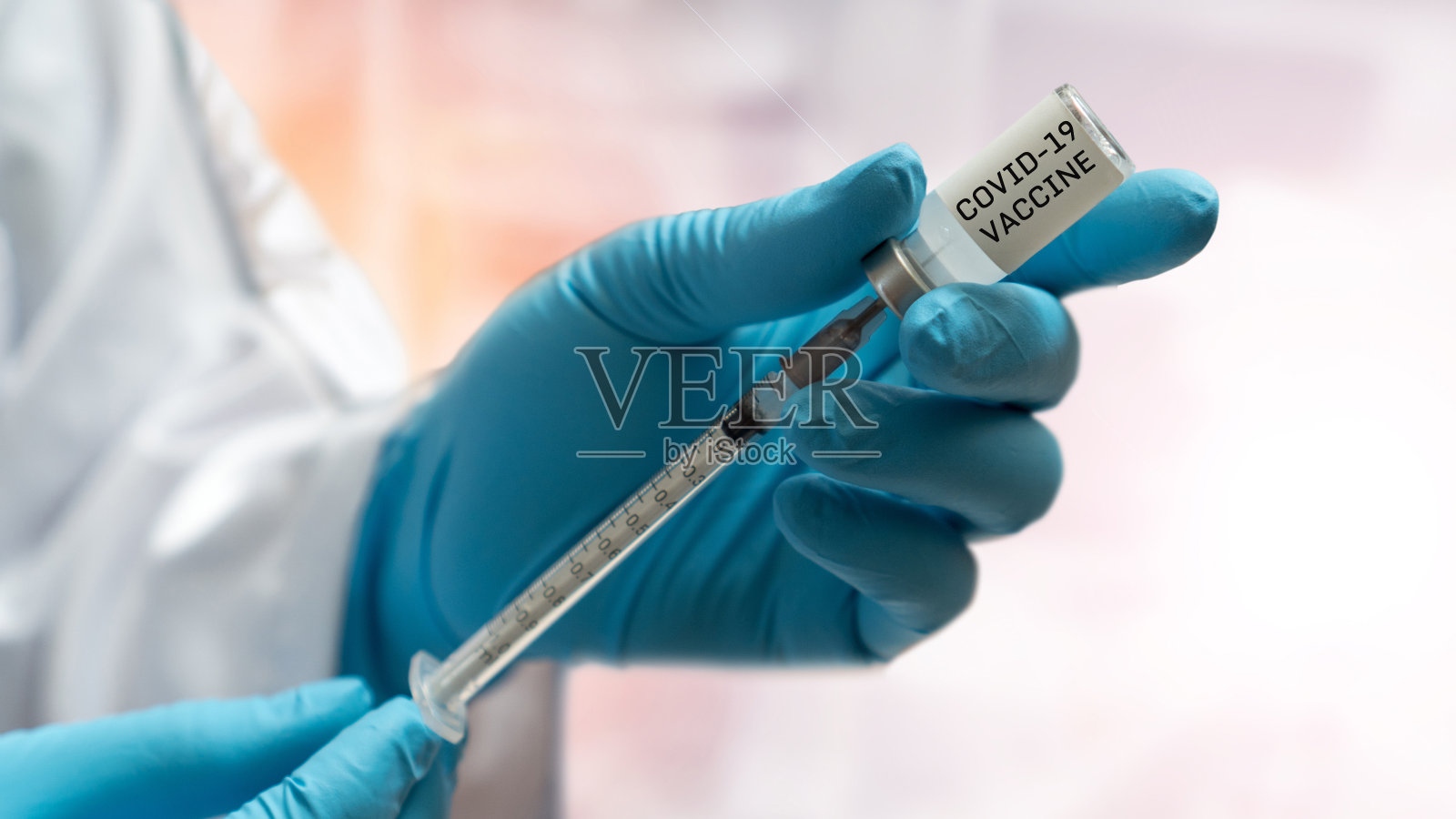 Covid-19疫苗的概念。医院实验室新型冠状病毒感染的医生手持医用手套、注射器和接种瓶照片摄影图片