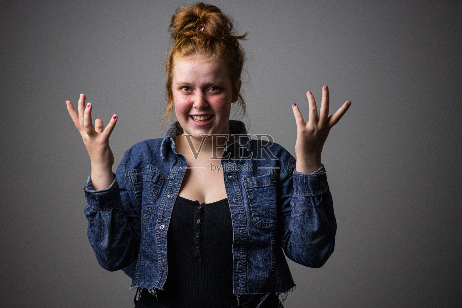 那么社交距离呢?一个没有安全感的学生试图微笑，想知道当她回到学校时会有什么规则。照片摄影图片