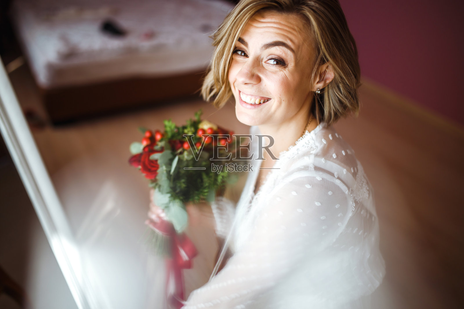 美丽的新娘与婚礼鲜花花束在白色豪华礼服准备婚礼。照片摄影图片