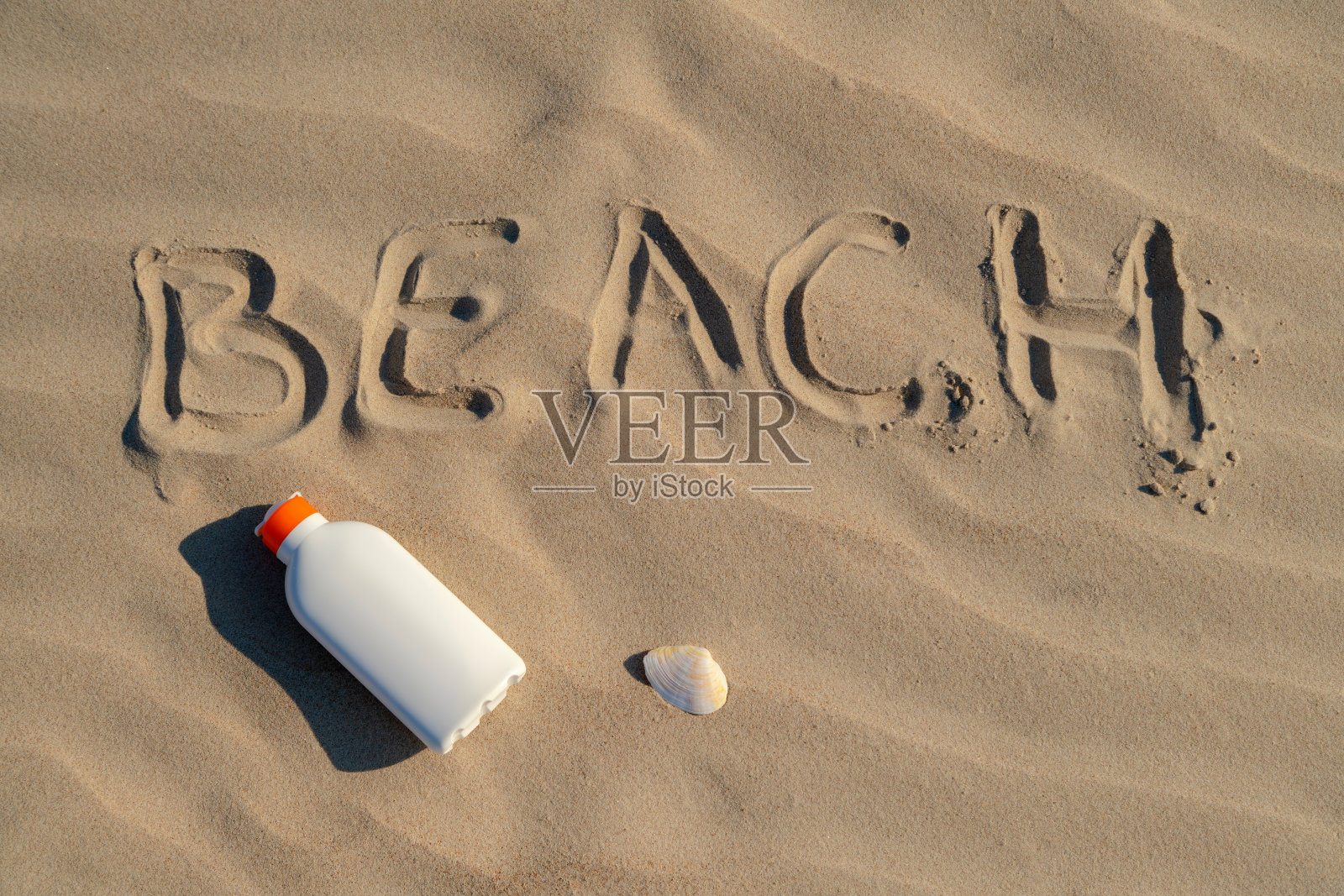 阳光明媚的日子，在沙滩上的沙滩上涂上防晒霜。白色防晒霜保护瓶防晒。没有人。照片摄影图片