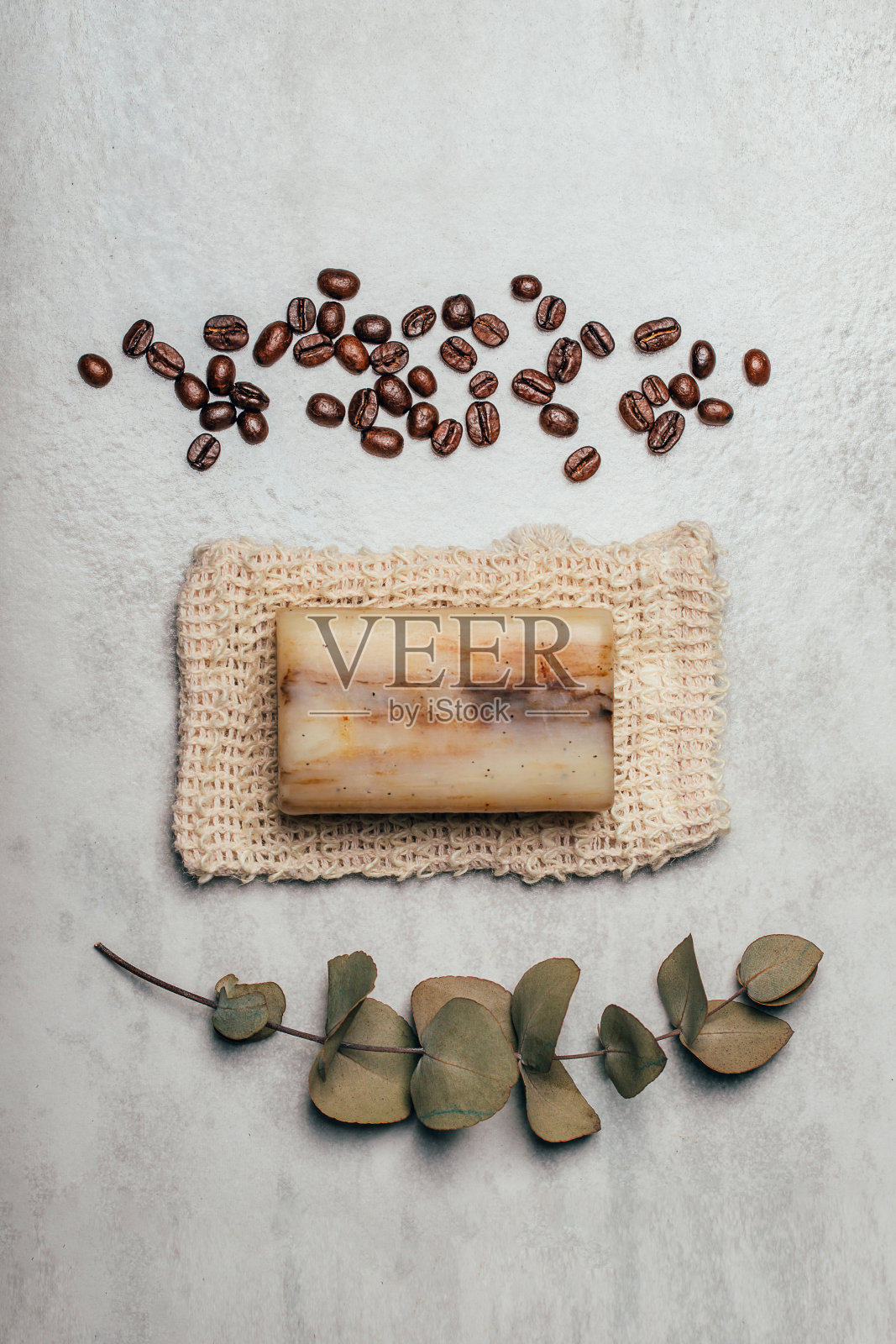 一块肥皂在自然袋与咖啡豆和桉树枝在乡村灰色背景。照片摄影图片