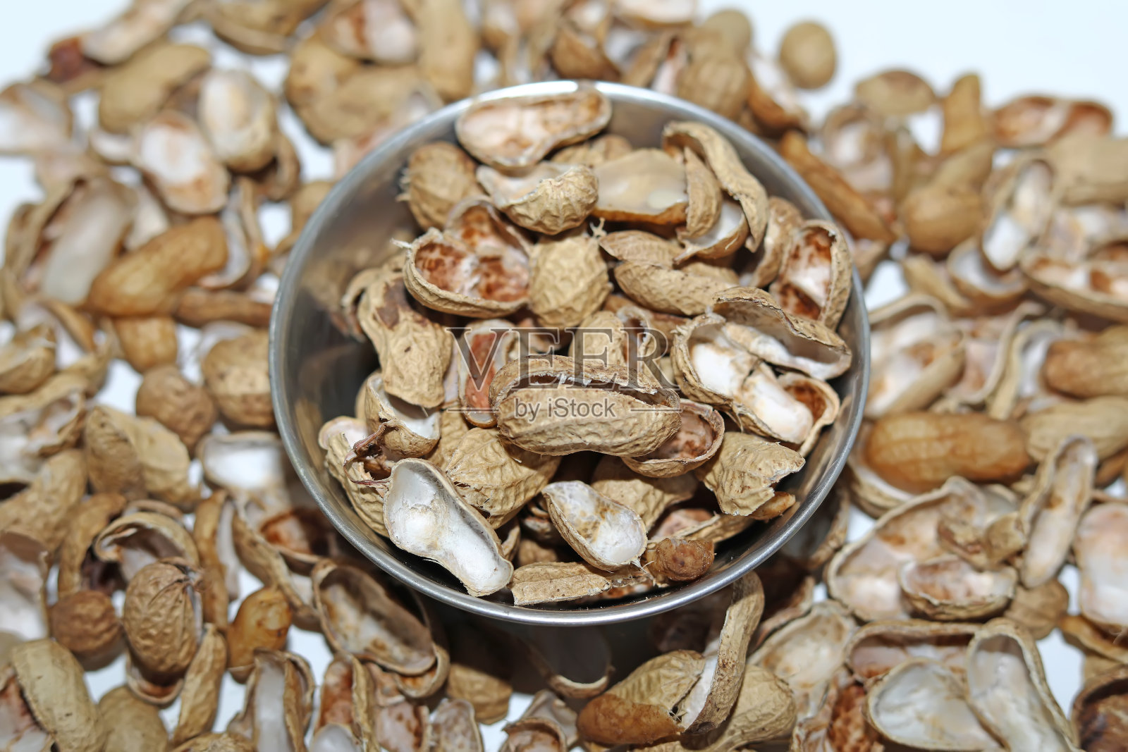 白底银碗里的花生壳照片摄影图片