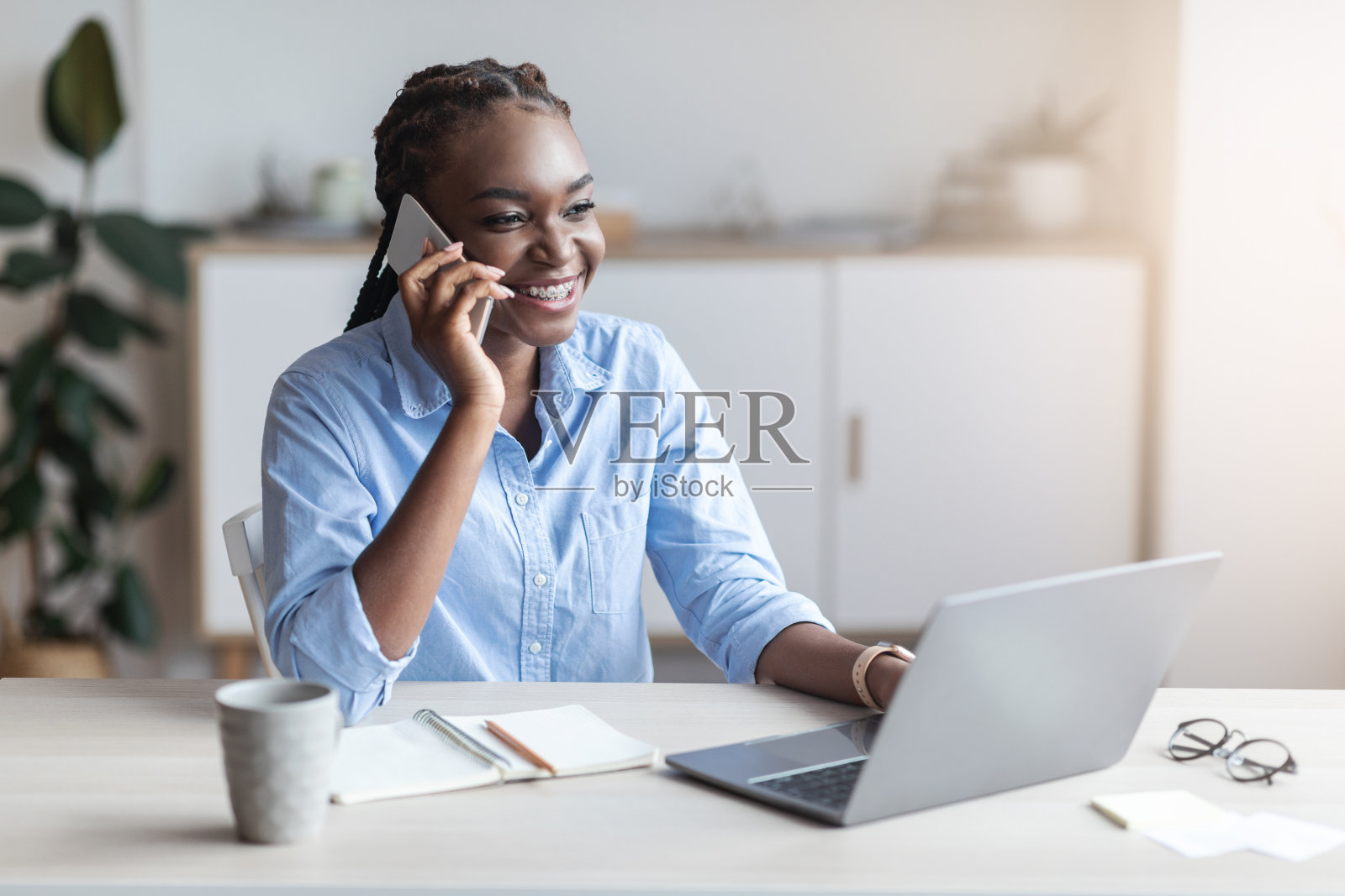 微笑的黑人女企业家在办公室打电话照片摄影图片