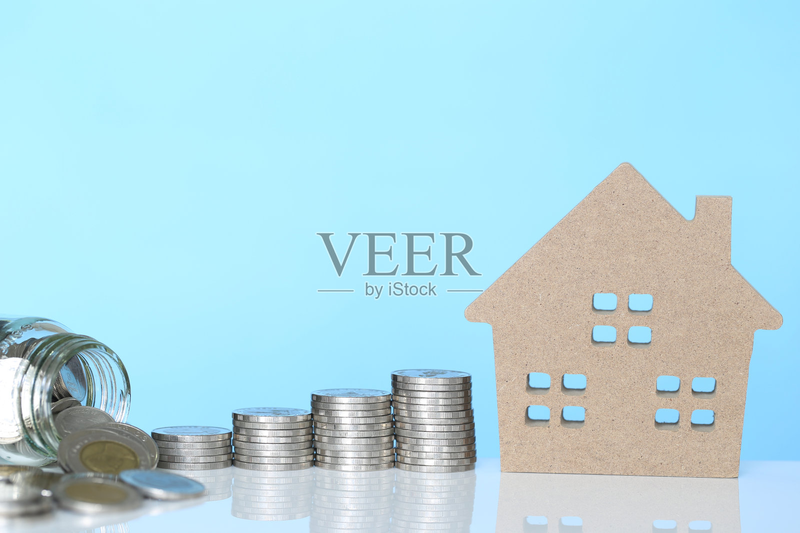 金融，硬币和蓝色背景的模型房子，商业投资和房地产照片摄影图片