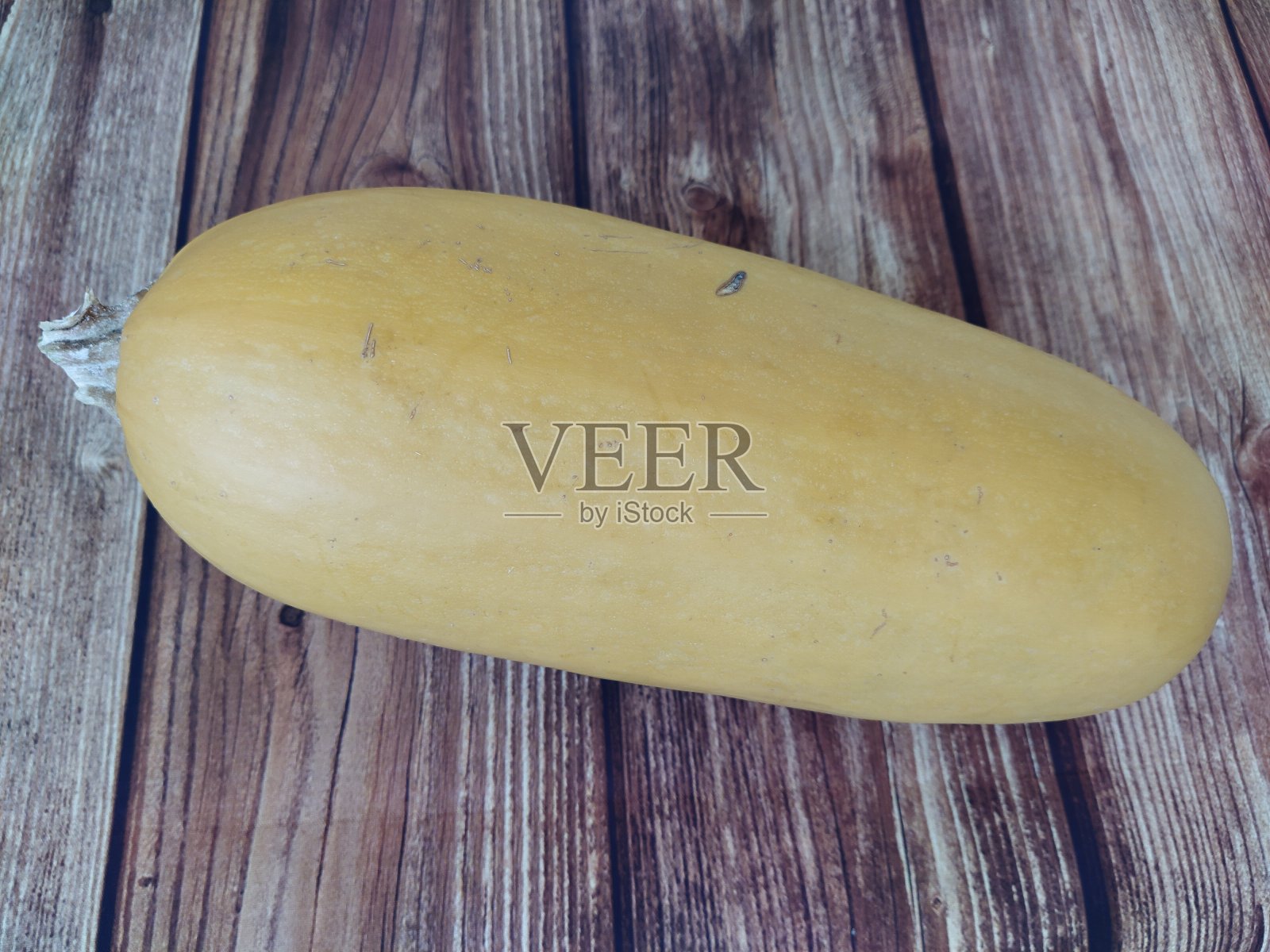 木桌背景上放着黄色的西葫芦照片摄影图片