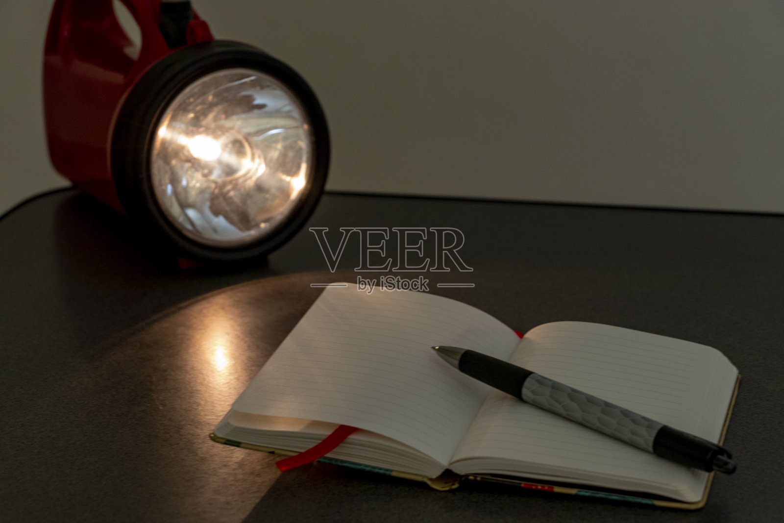 桌上有笔记本和手电筒照片摄影图片