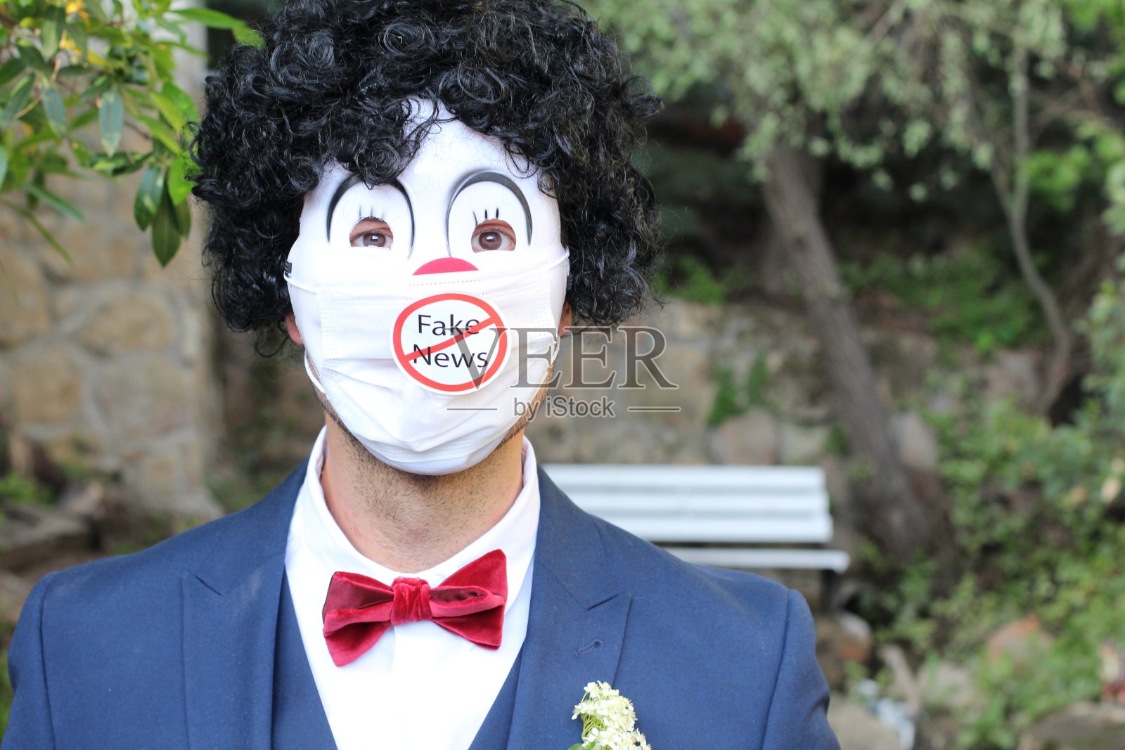 戴着外科口罩传播假新闻的小丑照片摄影图片