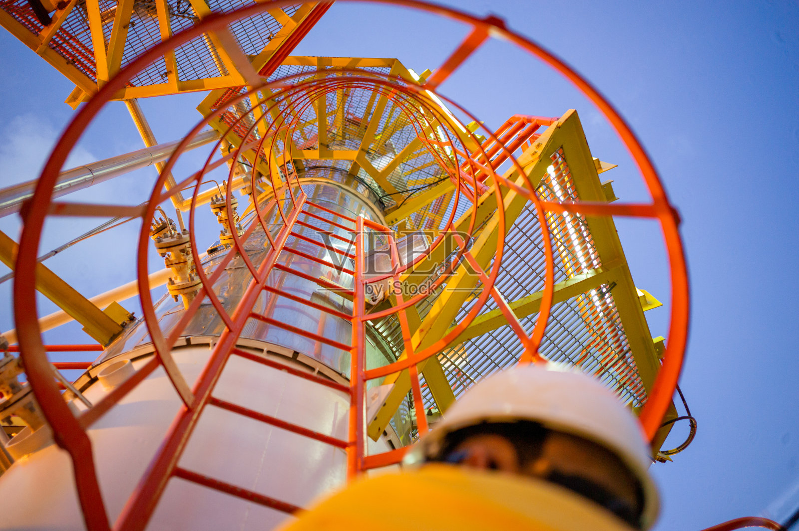 石油工人在安全笼梯自下而上照片摄影图片