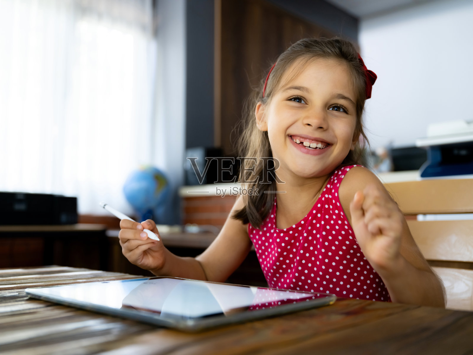 小女孩正在用手写笔在平板电脑上画画照片摄影图片