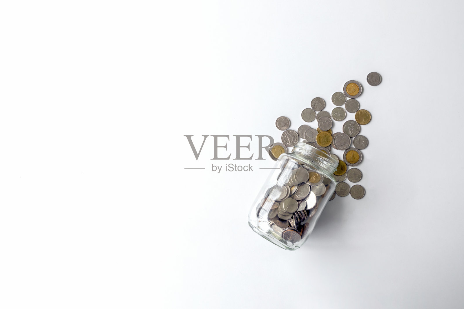 硬币(泰国货币)在白色的桌子上，以过光和柔和的焦点为背景照片摄影图片