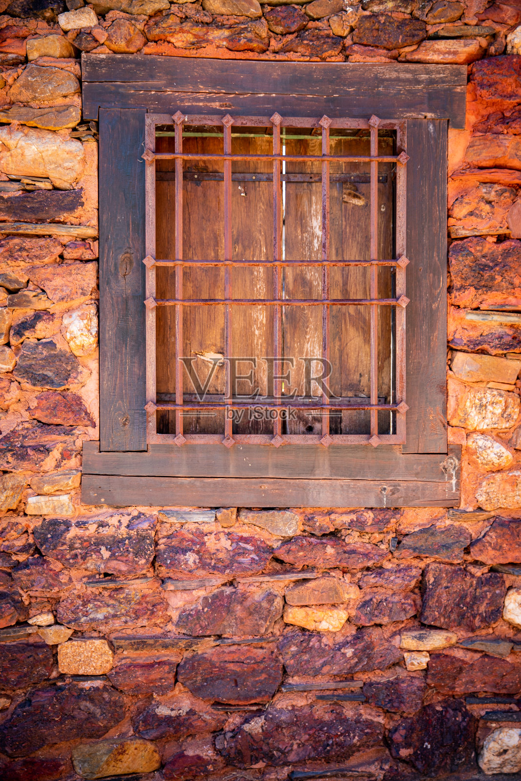 西班牙Madriguera村，红色石头建筑的一扇紧闭的窗户。照片摄影图片