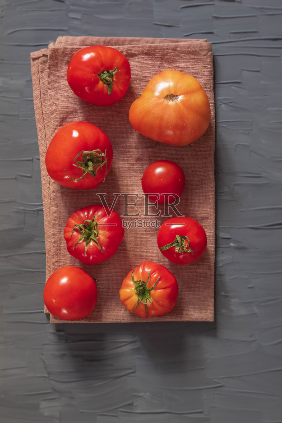 8个新鲜的西红柿放在一条棕色的毛巾上照片摄影图片