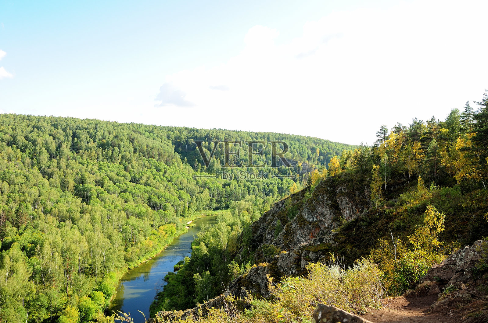 在一个温暖阳光明媚的日子里，一条平静蜿蜒的河流流过针叶林。河伯德,照片摄影图片
