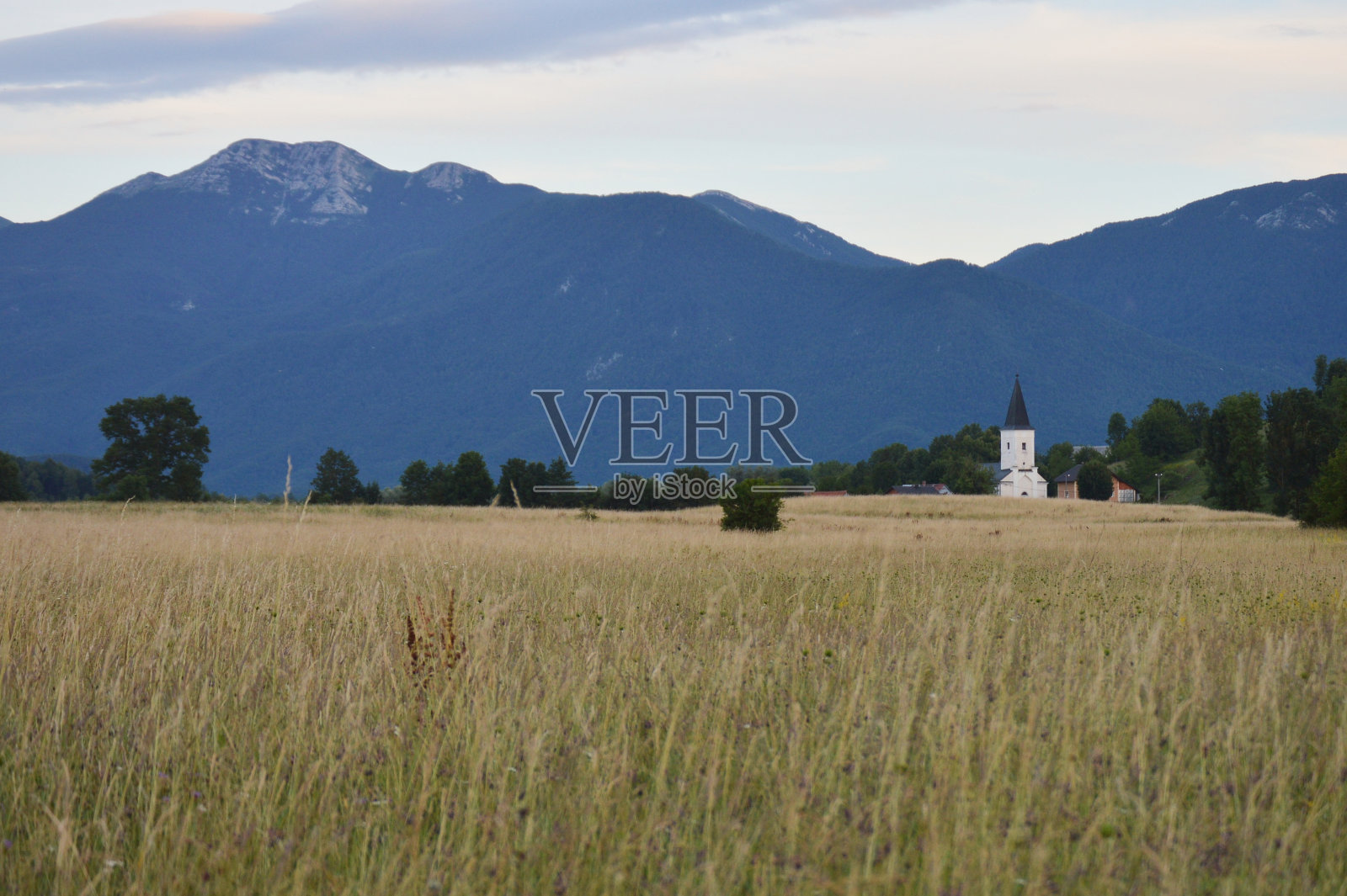 日落在南部Velebit (Visocica峰范围)在克罗地亚与草地和风景如画的村庄利奇诺维，利卡县照片摄影图片