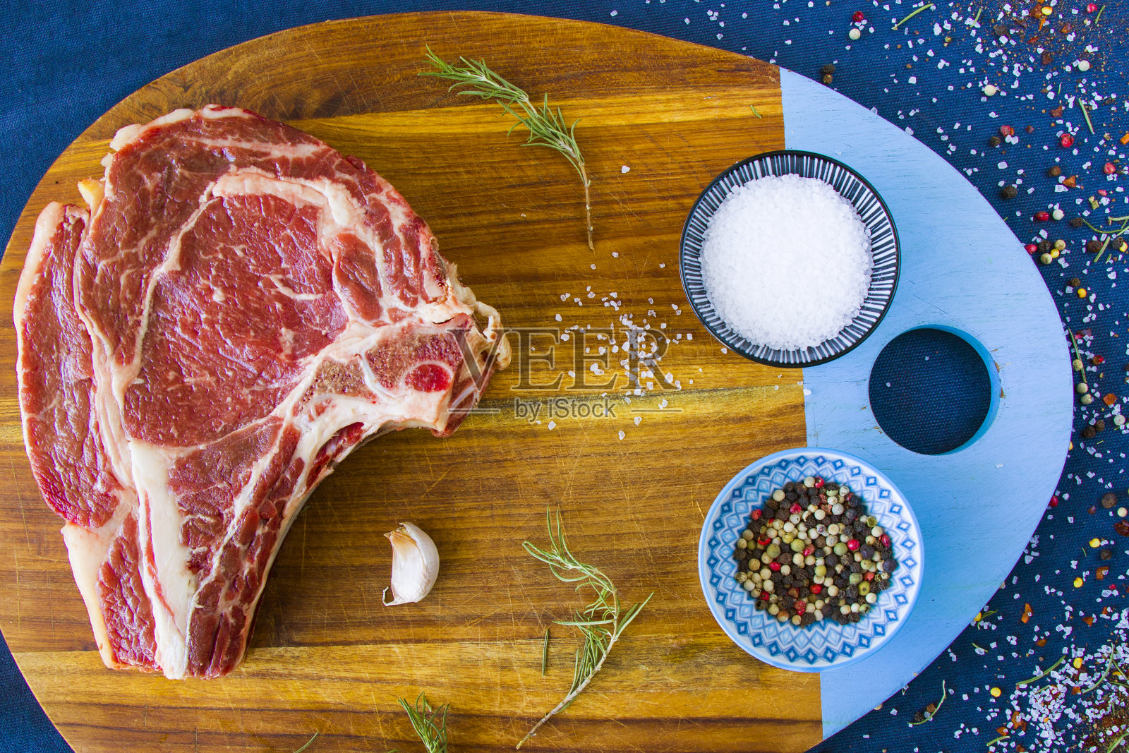 餐桌上的生牛肉、香料和迷迭香、肋眼牛排的配料。胡椒和粗盐。照片摄影图片