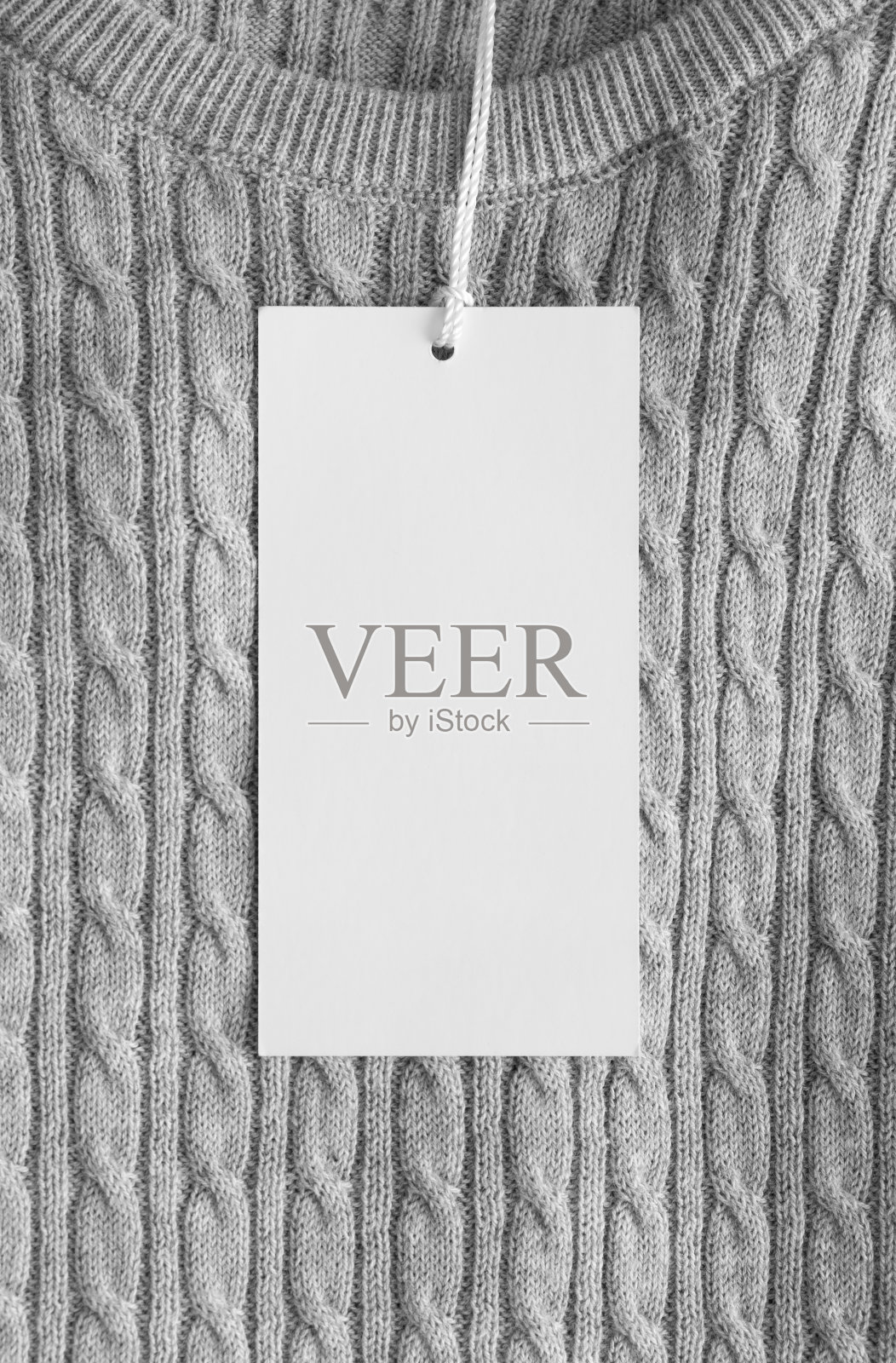 灰色毛衣上的白色衣服标签样板。照片摄影图片