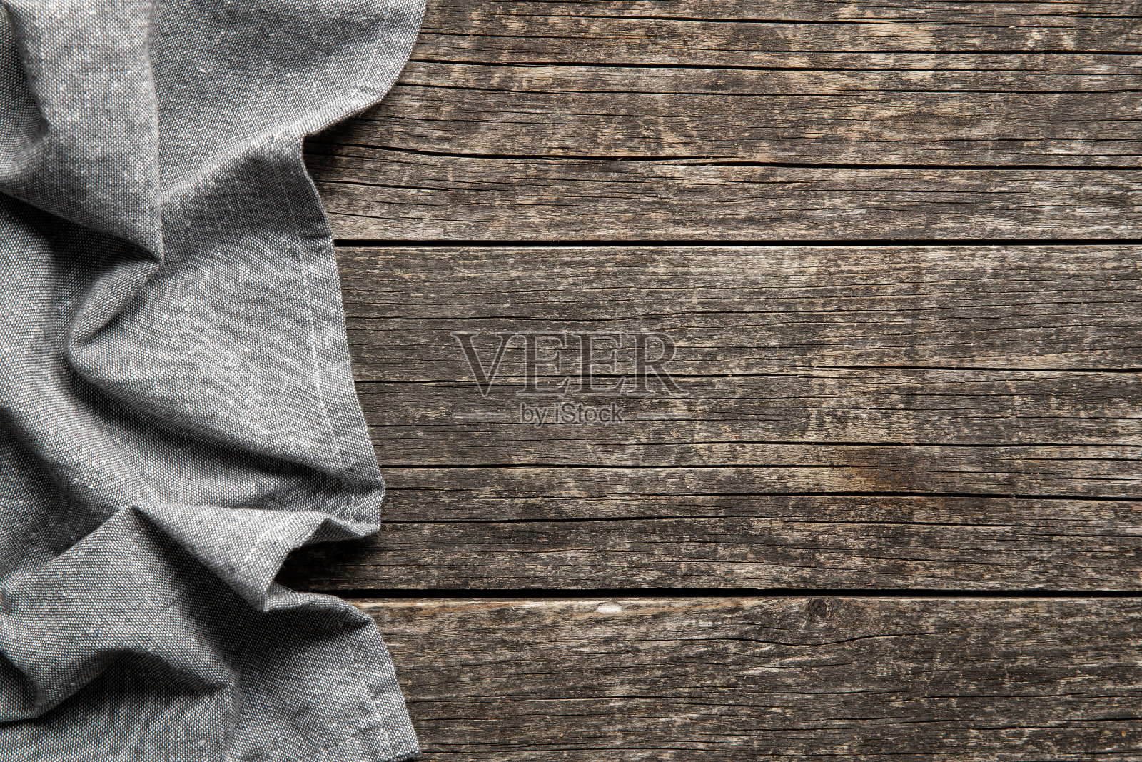 折叠的桌布盖在古董木桌上。照片摄影图片