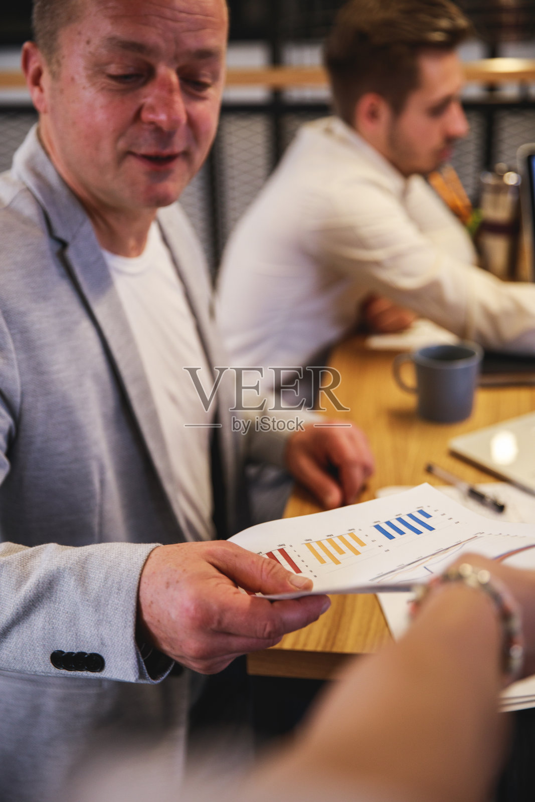 商业伙伴给他的同事递文件照片摄影图片