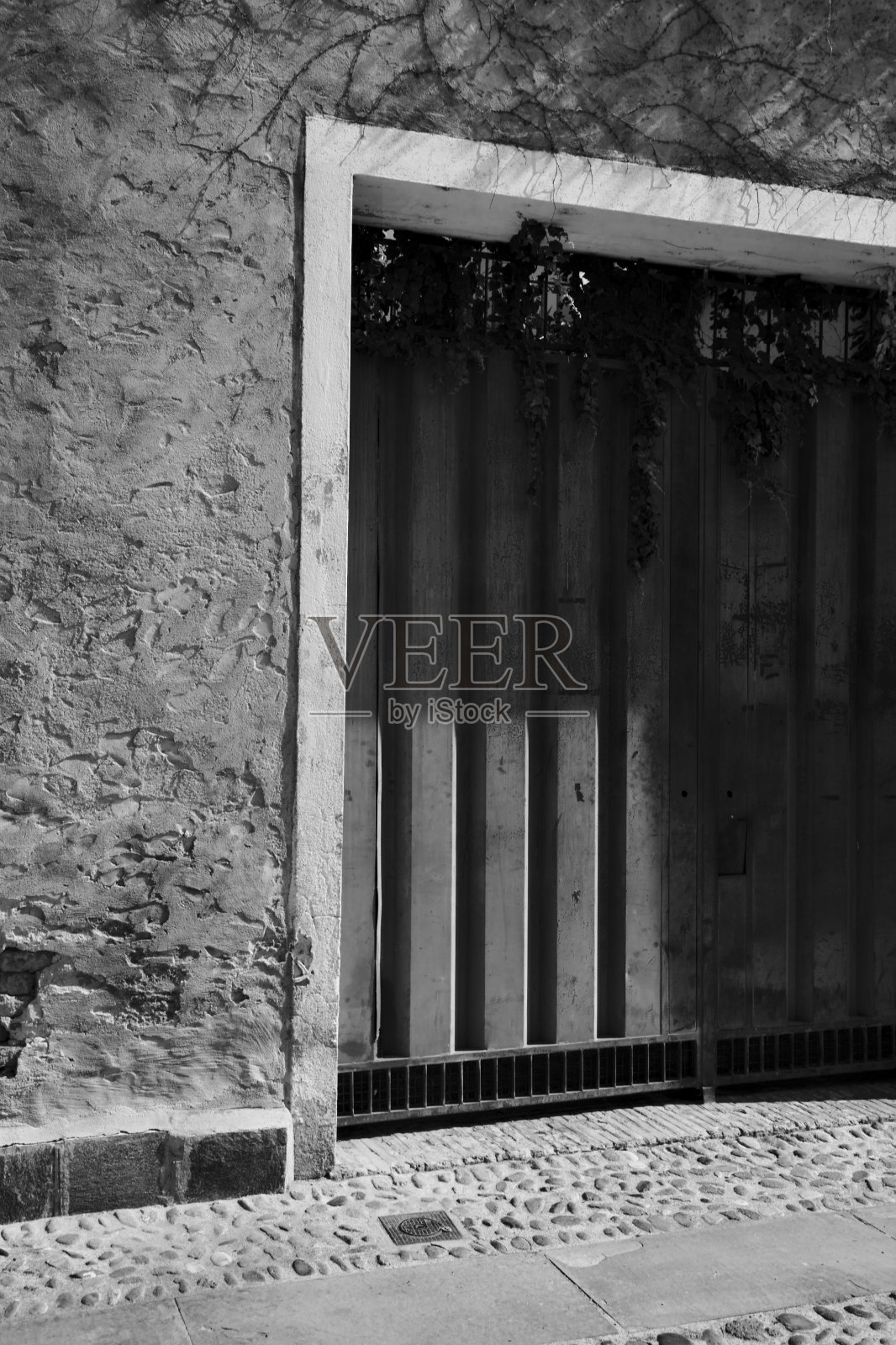 车库门和它旁边的道路标志在街道上是黑白的照片摄影图片