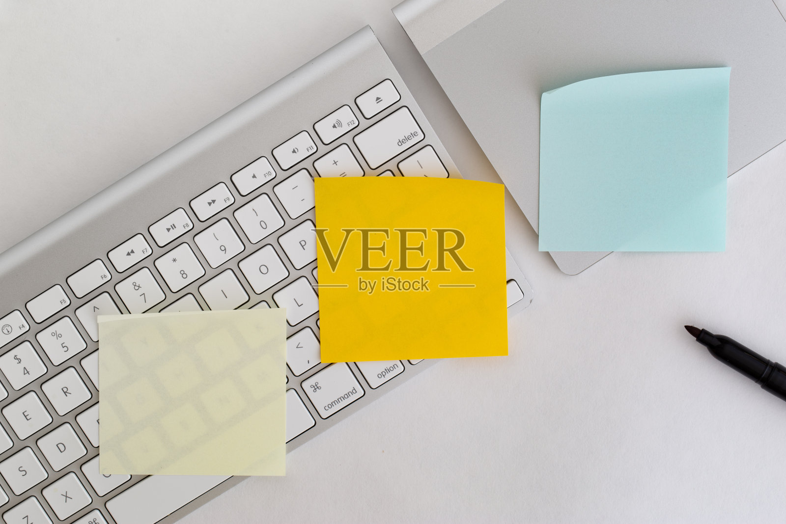 电脑键盘和一个触控板，上面有三张空白的便条和一支笔照片摄影图片