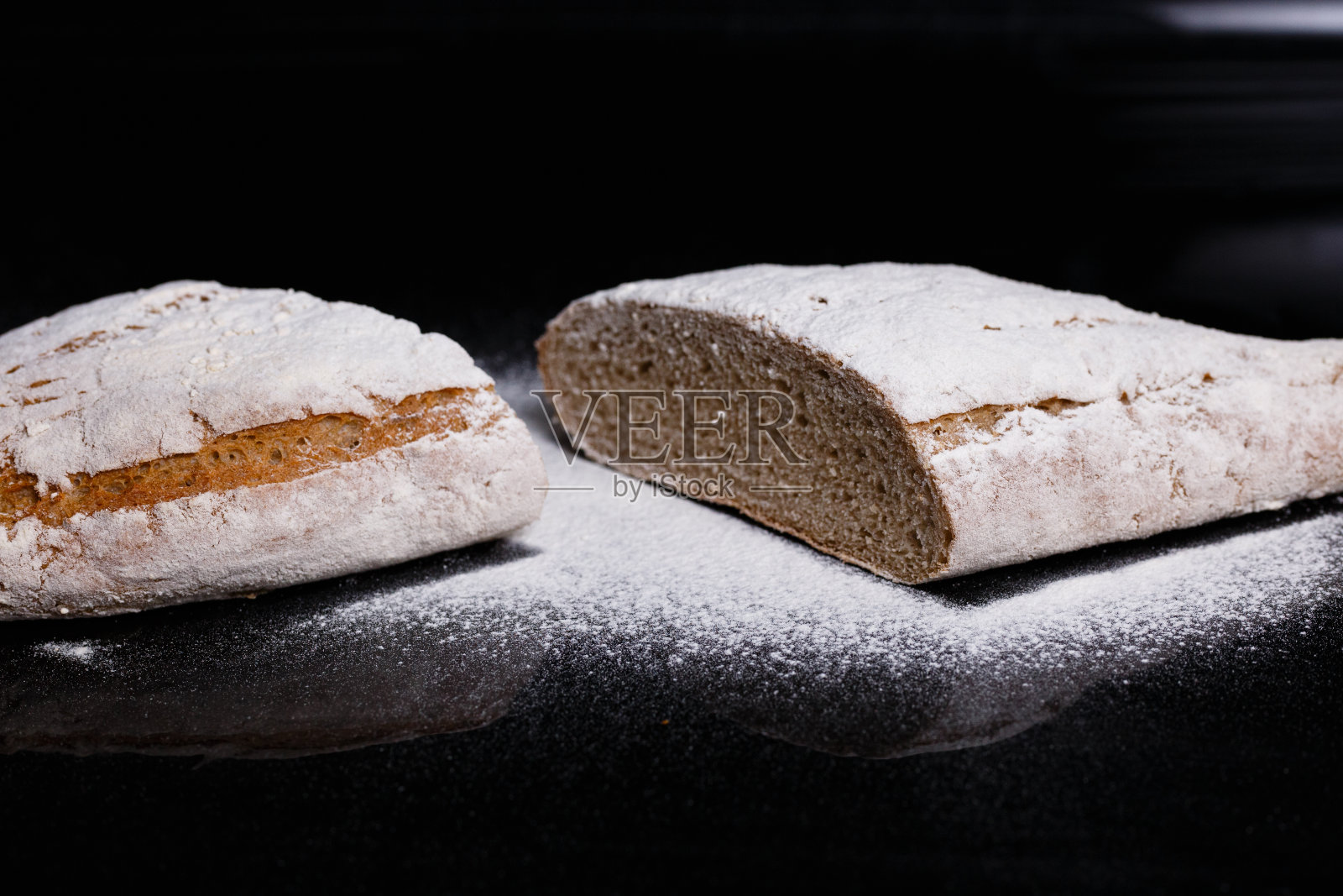 撒有面粉的灰色面包。自制点心，切面包照片摄影图片