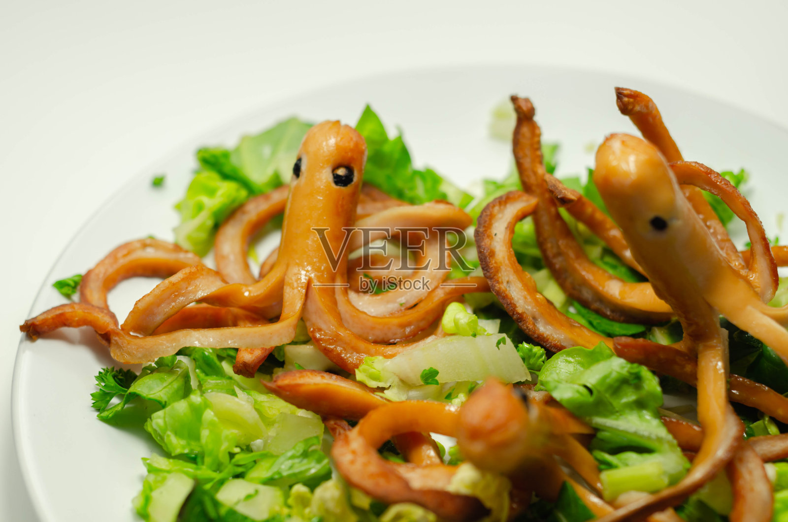 这是为孩子准备的创意餐，章鱼形状的油炸香肠配上新鲜的莴苣照片摄影图片